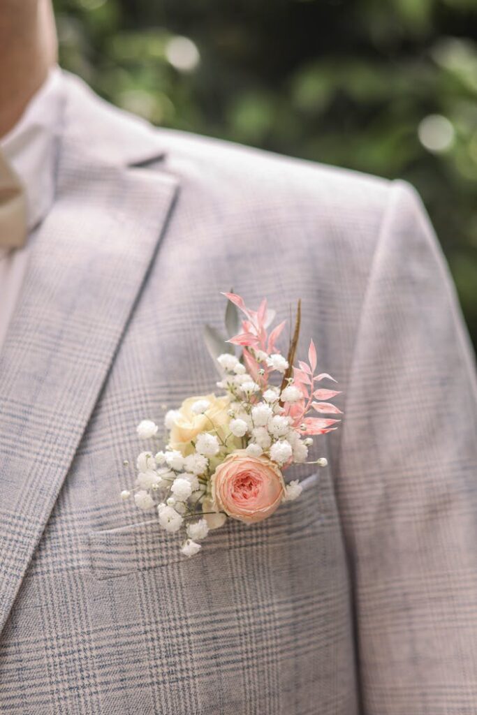 Close-up of a groom's suit and flower boutonnière, perfect for wedding fashion.