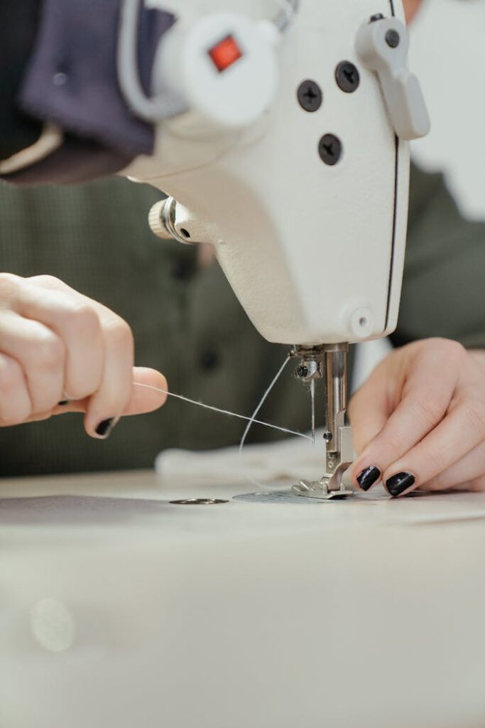 Detailed view of hands operating a sewing machine, showcasing needlework precision.